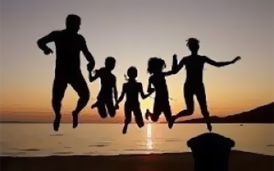 Family on the beach jumping for joy in the sunset